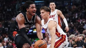 Toronto Raptors' Collin Murray-Boyles (left) drives past Miami Heat's Pelle Larsson (9) during first half NBA basketball action in Toronto on Thursday, April 9, 2026. THE CANADIAN PRESS/Nathan Denette